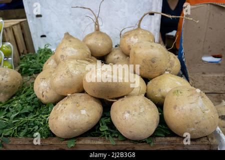 Fresh Mexican turnip (Yamboon or Jícama) on display at a market in Mexico, daytime Stock Photo