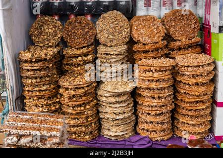 Mexican sweet snack (palanquetas) with peanuts, seeds and honey, display at market, piles of Stock Photo