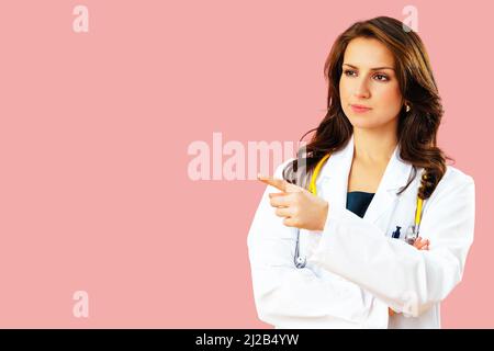 Portrait of serious female doctor or nurse looking to side at copy space and pointing with finger health care practitioner Stock Photo