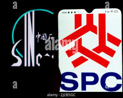 In this photo illustration, the Sinopec Shanghai Petrochemical Company Limited (Shanghai Petrochemical) logo is displayed on a smartphone screen with a China Petroleum & Chemical Corporation (Sinopec) logo in the background. (Photo by Igor Golovniov / SOPA Images/Sipa USA) Stock Photo