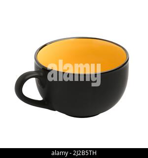 Large black yellow matte ceramic cup close-up isolated on white background Stock Photo