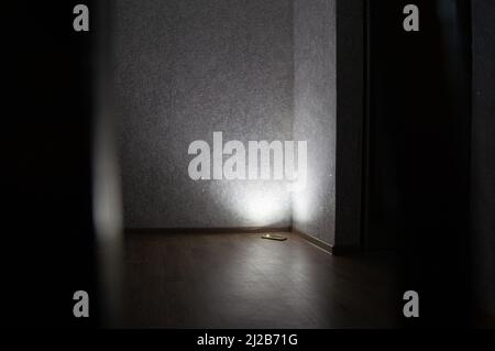 a wall lit by a phone flashlight is reflected in the whole room light Stock Photo
