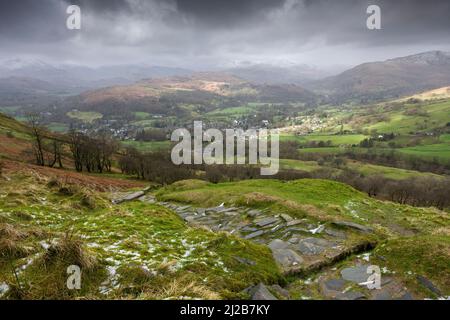 The view west from Wansfell over Ambleside, Loughrigg Fell and the snow-capped Cumbrian mountains beyond in the Lake District National Park, Cumbria, England. Stock Photo
