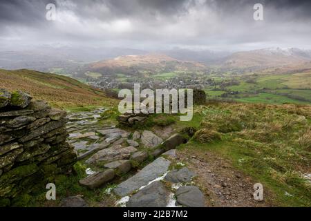 The view west from Wansfell over Ambleside, Loughrigg Fell and the snow-capped Cumbrian mountains beyond in the Lake District National Park, Cumbria, England. Stock Photo