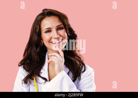 Close up studio portrait of a smiling young female doctor or nurse with stethoscope looking ahead health care practitioner Stock Photo
