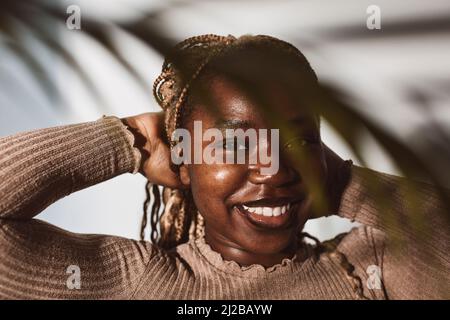 Smiling woman with hands behind head against white background Stock Photo