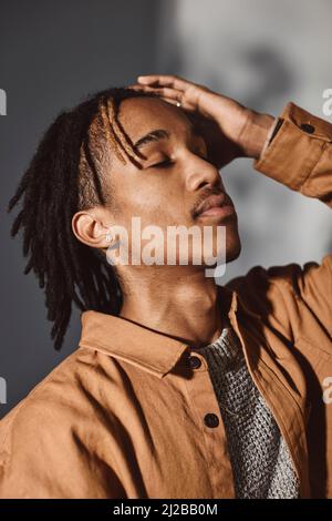 Young man with hand in hair at studio Stock Photo