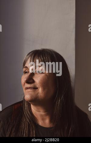 Mature woman looking away over white background Stock Photo