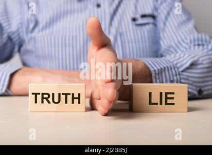 Man divides blocks with words truth and lie. Confrontation between true and false information, news, actions. Choice between deception and honesty. High quality photo Stock Photo