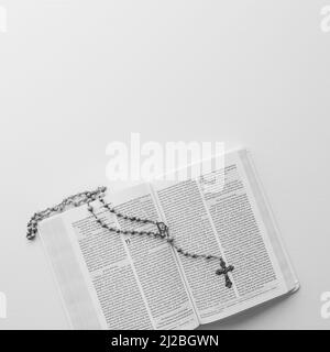 Rosary Catholic prayer beads laying on an open bible with copy space Stock Photo