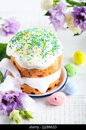 Traditional Easter sweet bread or cakes with white icing and sugar decor and quail eggs over white wooden table. Various Spring Easter cakes. Happy Ea Stock Photo
