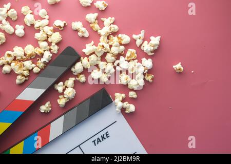 Movie clapper board and popcorn on red background  Stock Photo