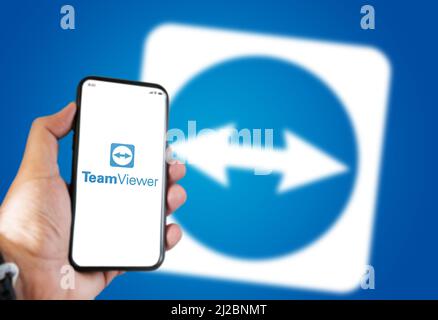 New York, USA, September 2021: hand holding a phone with the Teamviewer app on the screen and the icon blurred on the background.