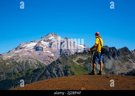 WA21238-00...WASHINGTON - Hiker viewing Glacier Peak from the crest of the White Chuck Cinder Cone in the Glacier Peak Wilderness Area. Stock Photo
