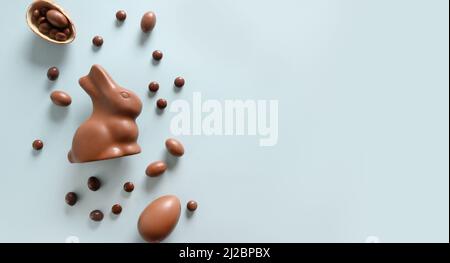 Happy Easter greeting card with chocolate sweets rabbit, eggs on blue background. Concept egg hunt. Stock Photo
