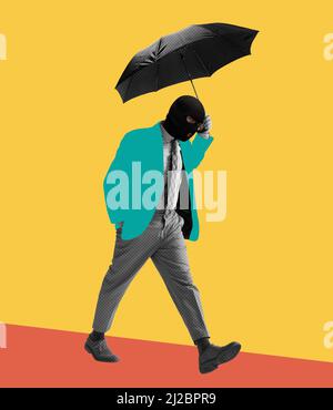 Contemporary art collage. Colorful design. Man in black balaclava walking with umbrella isolated over yellow background Stock Photo
