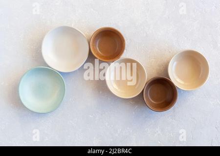empty ceramic bowls in S-shape form, top view, pastel colors Stock Photo