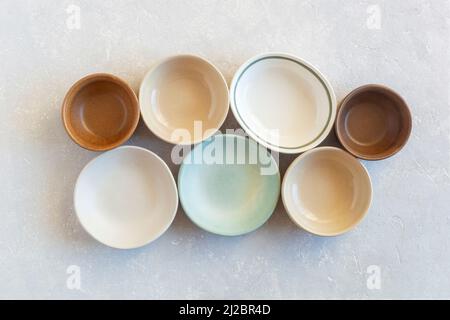 set of many empty soft color ceramic bowls of different forms, top view Stock Photo