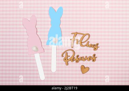 Blue and pink paper rabbit silhouette and Felices Pascuas word in handwrite wooden letter (happy easter) Stock Photo