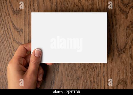 Woman's hand holding blank paper with a space for text Stock Photo