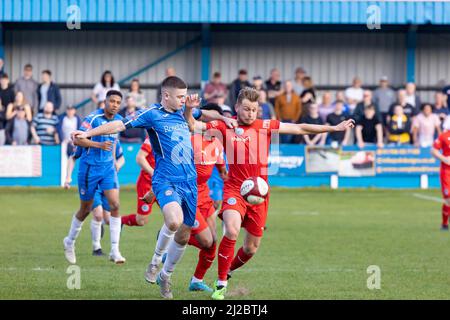 Rylands player David Webb has his shirt pulled while chasing a high ball at Ramsbottom United FC's ground Harry Williams Riverside Stadium Stock Photo