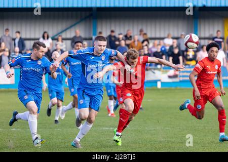 Rylands player David Webb has his shirt pulled while chasing a high ball at Ramsbottom United FC's ground Harry Williams Riverside Stadium Stock Photo