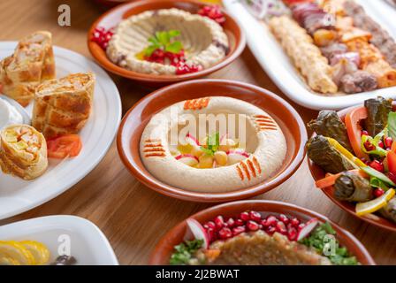 Multiple lebanese appetizers and salads togeather on the table. focused on hummus Stock Photo