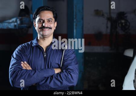 A man when building a car with metal tools in hand in Navneet Sharma, India Stock Photo