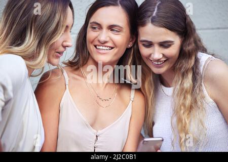 We should spend more time together. Shot of young female friends using a smartphone. Stock Photo
