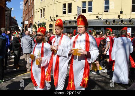 Cardiff, Wales - March 2022: Rugby supporters dressed as bishops carrying pints of beer in Cardiff city centre on day of an international rugby match Stock Photo