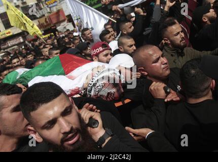 Jenin, Palestine. 31st Mar, 2022. (EDITORS NOTE: Image depicts death) Mourners carry the body of Yazid Al-Saadi, 23, who was killed during an Israeli army raid on Jenin refugee camp in the West Bank. Palestinian medical sources said that 14 Palestinians were injured during this raid. (Photo by Nasser Ishtayeh/SOPA Images/Sipa USA) Credit: Sipa USA/Alamy Live News Stock Photo