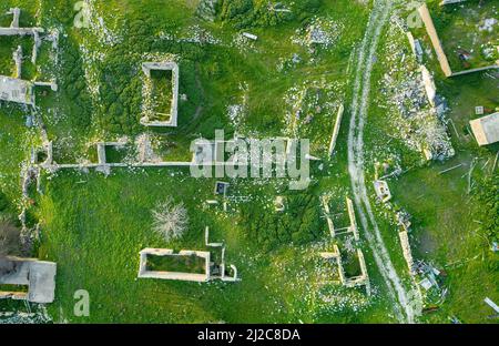 Abandoned traditional village with ruins of houses and unpaved road, view from above Stock Photo
