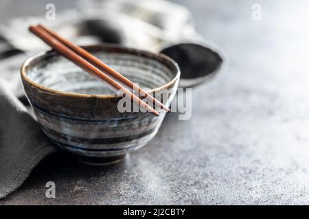 Empty bowl and chopsticks on a kitchen table. Stock Photo