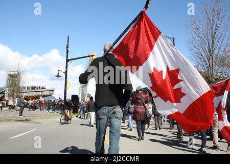 A Man carrying Canadian flag on ice hockey stick in downtown Vancouver, British Columbia, Canada Stock Photo