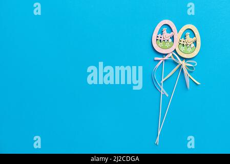 Easter decor in the form of wooden eggs on a stick on a blue background Stock Photo