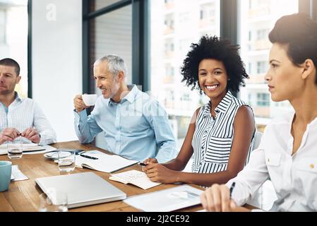 This meeting is in full swing. Portrait of a young businesswoman sitting in a meeting with her colleagues. Stock Photo