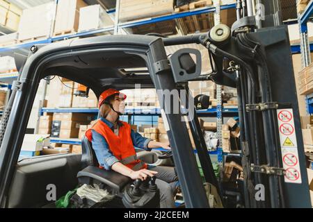 Young female forklift driver working in a warehouse Stock Photo