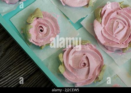 Homemade marshmallows of different shapes and colors. Zephyr flowers. On pine boards. Stock Photo