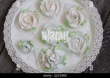 Homemade marshmallows of different shapes and colors. Zephyr flowers. On pine boards. Stock Photo