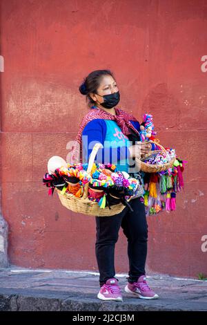 A female, vender selling a myraid of Mexican folk art. San Miguel de Allende, Guanajuato, Mexico Stock Photo