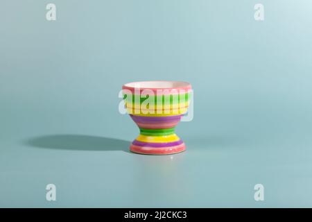 Striped egg cup on a green background. Close-up. Stock Photo