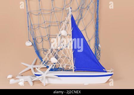 Small sailing boat decoration with starfish and seashells and copy space  Stock Photo - Alamy