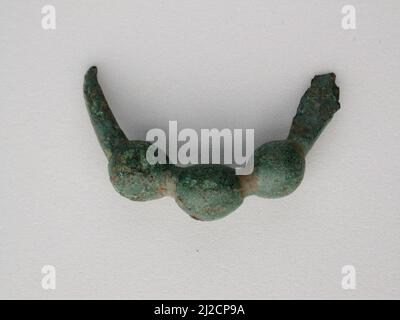 This precious bronze object is a votive, or devotional gift, made as an offering to the gods. They come in many forms, such as animals, beads and brooches. Many seem once to have been attached to something else. Votives were hung from sacred trees or placed in sanctuaries around Greece. Once a shrine was full, the votives were ceremonially buried to make room for more offerings. Stock Photo