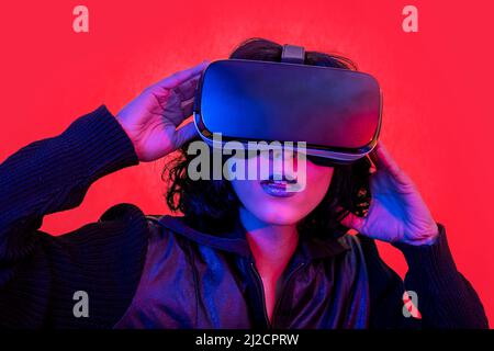 The young woman is using the virtual reality headset. Modern woman portrait with trendy look and bright colors. Stock Photo