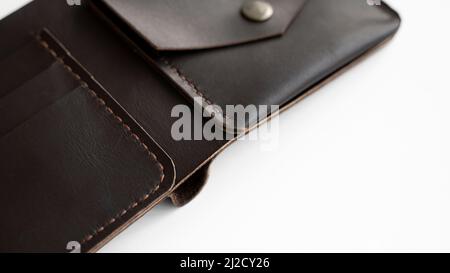 Top view of open brown empty man's black handmade genuine leather wallet with pockets for banknotes, credit cards and monets isolated on white Stock Photo