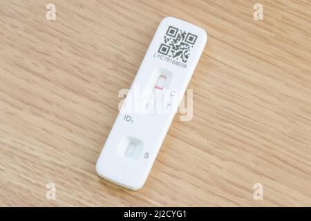 UNITED KINGDOM - March 26, 2022. LFT testing. Covid 19 lateral flow test strip on a wooden desk. Red line indicating a negative result. Covid testing Stock Photo