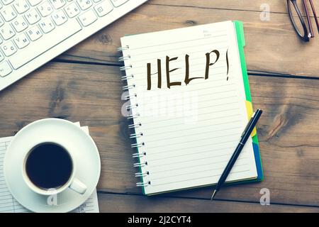 Help word writing on paper and keyboard, coffee with glasses on table Stock Photo
