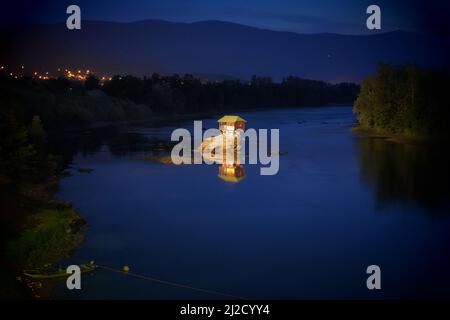 wooden house on river by night, Serbia Stock Photo