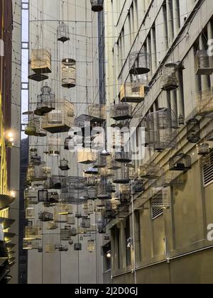 The Forgotten Songs, artistic installation of empty birdcages hanging in Place laneway, Sydney Australia Stock Photo