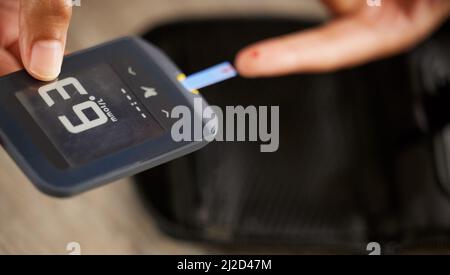 Thats a little high but nothing to worry about. High angle shot of an unrecognizable woman testing her blood sugar level at home. Stock Photo